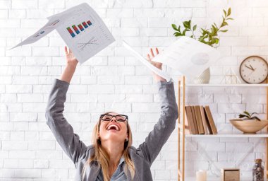 Uzaktan çalışmada iyi günler. Gülen kadın kağıtları fırlatıyor.