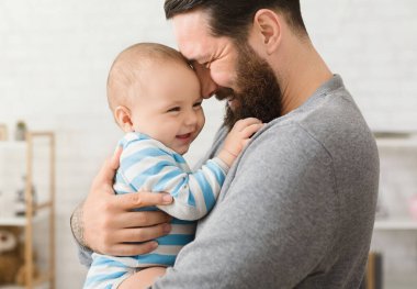 Neşeli baba ve oğul evde sarılıyor, birlikte vakit geçiriyorlar.