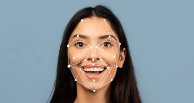 A young woman beams with a bright smile as facial recognition markers are overlaid on her face. The light blue background enhances her joyful expression, highlighting technological innovation. clipart