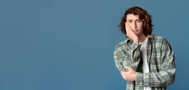 Yakışıklı milenyum çocuğu. Renkli arka planda sıkılmış ya da yorgun hissediyor.