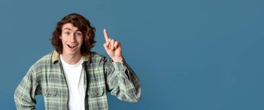 Çekici genç adam dikkat çekiyor, turkuaz arka plan hakkında yaratıcı fikirleri var.