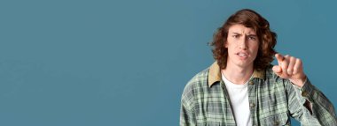 Hüsrana uğramış genç, turkuaz arka plan suçlamasıyla seni işaret ediyor.