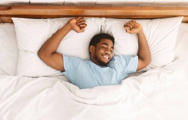 Rahat uyu. Uyku, yatak, üstten görünüm yayılmış Afro-Amerikan bin yıllık erkek gülümseyen