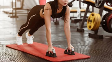 Güç egzersizi. Güzel bir genç kadın spor salonunda yoga minderinde egzersiz yapıyor.