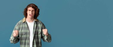 Çatışma konsepti. Kızgın milenyum adamı renk arkaplanını yumrukluyor