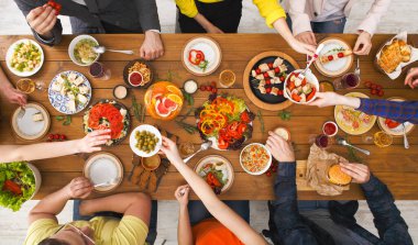 Arkadaşların yemek partisi, masa üstü manzarası. İnsanlar birlikte sağlıklı yiyecekler yerler.