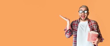 Duygusal heyecanlı gözlüklü ve patlamış mısırlı adam film izlemeye hazır, sarı arka planda, boş alan