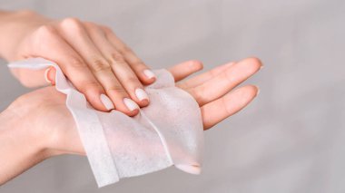 Salgın sırasında hijyen. Kız ellerini antiseptik peçeteyle siliyor.