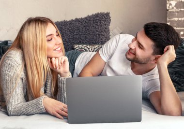 Genç mutlu çift evlerinde dizüstü bilgisayarla ne alacaklarını tartışıyor, online alışveriş ve internet teknolojisi ev, panorama