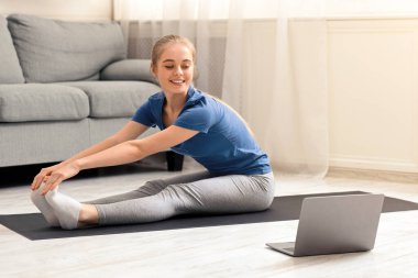 İnternette pilates çalışması. Koçla internet, panorama ve boş alan üzerinden antrenman yapan genç bayan sporcu.