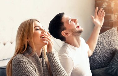 Gülen adam ve kadın evdeki komedi şovundan zevk alıyorlar.