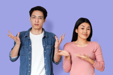 Alaycı Asyalı kız duygusal erkek arkadaşını işaret ediyor. Gri arka plan yüzünden tecrit sırasında kavga ediyor.