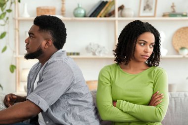 Quarrels Karantinası. Afrika kökenli Amerikalı çift, evde tartıştıktan sonra birbirlerini görmezden gelip koltuğun farklı taraflarında oturuyorlar.