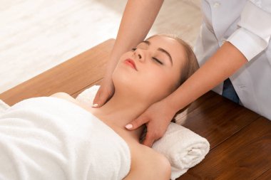 Güzeller güzeli genç bir kadın masaj yaptırıyor ve dinleniyor.