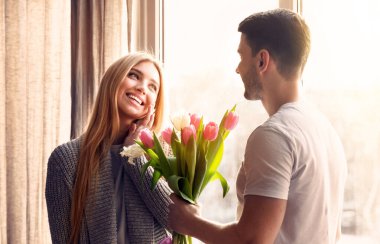 Romantik bir an. Genç adam özel bir günde kız arkadaşına çiçek veriyor.