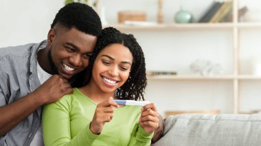 Evli siyah çift, hamilelik testinin pozitif sonuçlarıyla mutlu, karısını seven bir adam, fotokopi odası.