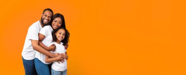 Sağlıklı Aile İlişkisi. Afrikalı Amerikalı anne ve babanın portresi. Sarı stüdyo arka planında izole edilmiş gülümseyen kıvırcık kız çocuğu. Pankart, panorama, bedava fotokopi alanı.