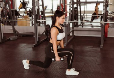 Spor kulübünde dambılı genç bir kadın hamleler yapıyor.