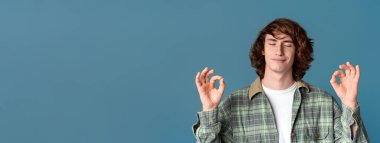 Uyum ve meditasyon konsepti. Kapalı gözlü, turkuaz arka plan üzerinde meditasyon yapan tuhaf bir adam.