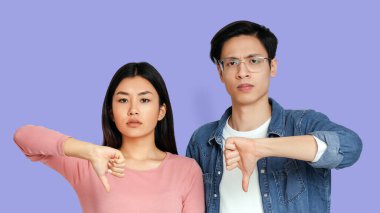 Gri stüdyo geçmişi olan Asyalı genç bir çift.
