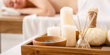 Ayurvedik masaj. Tuz, mumlar, aromatik çubuklar, otlarla dolu çantalar, yakın plan, masadaki kıza masaj yapmak.