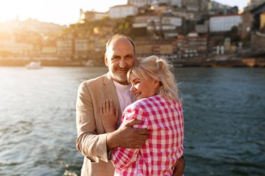 Günbatımında Porto 'nun manzaralı güzelliğiyle çevrili neşeli bir çift kucaklaşır. Canlı renkler su kenarında geçirdikleri zamanın keyfini çıkarırken romantik bir atmosfer yaratıyor..