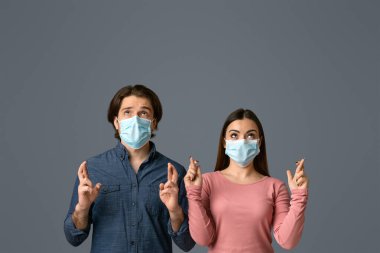 Koruyucu tıbbi maskeli batıl inançlı çift Coronavirüs salgınına karşı savaşmak umuduyla şans diliyor.