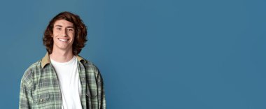 Komik milenyum çocuğu, kıvırcık saçlı, turkuaz sırtına gülümseyen.