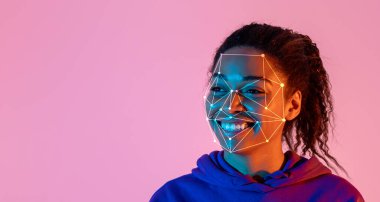 Yüz tanıma teknolojisi yüzünü geometrik desenlerle örterken Afro-Amerikalı kadın parlak bir şekilde gülümsüyor. Parlak ışık görsel ve modern bir atmosfer yaratır..
