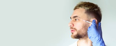 Yaş değişir. Güzellik uzmanı gri arka plandaki adama yaşlanma karşıtı iğneler yapıyor.
