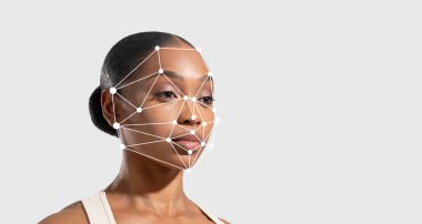 Yüzündeki yüz tanıma teknolojisi örtülürken Afro-Amerikalı kadın tarafsız bir ifadeyle ayakta duruyor. Bu yapay zekada insan tanımlaması ve analizi için gelişmeler gösterir..