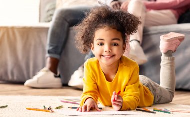 Kalemlerle çizen küçük kıza odaklan. Afrika kökenli Amerikalı baba ve Avrupalı anne