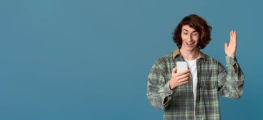 Piyango talihlisi. Arka planda cep telefonuna bakan hayret verici bir genç.