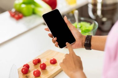 Diyet Planlama Konsepti. Sağlıklı yemek arka planında cep telefonu kullanan kadın eller, omzunun üstünden bakın, modelleyin.