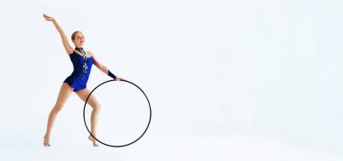 Sanatsal jimnastik. Profesyonel sporcu, beyaz arka planda izole edilmiş, çemberli performans sergiliyor.