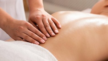 Masa masajı sırasında çıplak kızlar sırt üstü yatar.