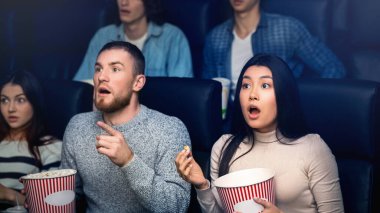 Eğlence ve eğlence. Patlamış mısırlı bir grup duygusal insan sinemada gerilim filmi izliyor.