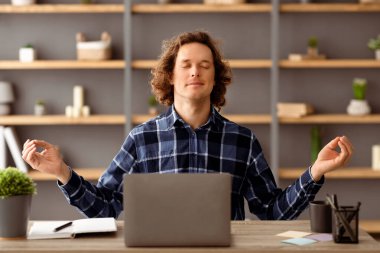 Genç İşadamı Gözleriyle Oturan Meditasyon Modern Ofis 'teki İş Yeri' nde Dinleniyor. Meditasyon yapan adam içeride rahatlama egzersizi yapıyor. Sakin ol, konsept. Seçici Odaklanma