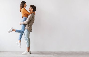 Romantik genç Asyalı adamın sevgilisini beyaz stüdyo duvarına yaslayıp kucaklamasını, fotokopi çekmesini. Milenyum eşleri için sevgi ve sevgiyi ifade eden tam boy