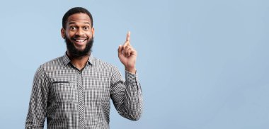 Mükemmel bir fikir. Genç siyahi adam parmağını kaldırıyor, problem çözümü var, mavi arkaplan