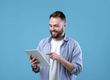 İnternet işi için tablet bilgisayar kullanan neşeli sakallı bir adam ya da mavi stüdyo geçmişi üzerine çalışmalar yapan. Pozitif öğretmen uzaktan ders veriyor. Sosyal ağ için yeni bir gönderi oluşturan blogger