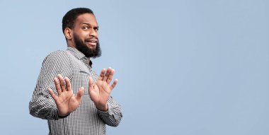 Iyy, çok iğrenç. İğrençlik ifadesi olan genç Afrikalı bir adam bir şeyi reddediyor ve lütfen dur diyor, mavi duvar.