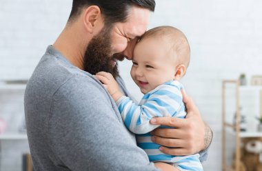 Aile sevgi ve sevinç. Mutlu baba onun gülen bebek ile kucaklayan