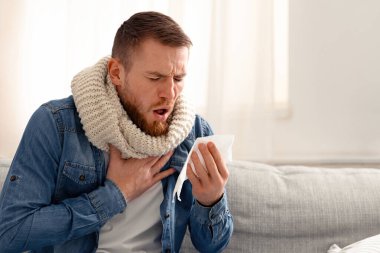 Coronavirus enfeksiyon kapmış bir adam evde ağır öksürüyor.
