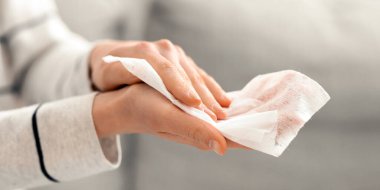 Temiz eller hükmeder. Kız ellerini antibakteriyel peçetelerle yıkıyor.