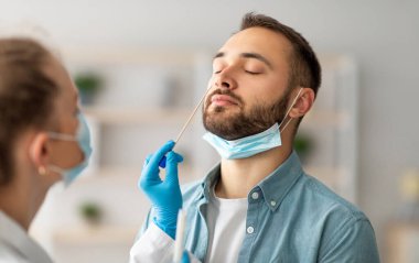 Burun koronavirüsü PCR testi. Doktor, evdeki enfekte olma ihtimali olan genç çocuktan virüs örneği almak için çubuk çubuğu kullanıyor. Viral hastalıkların önlenmesi ve tanı konsepti