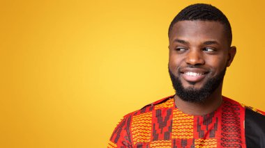 Gülümseyen ve boş alana bakan, sarı stüdyo arka planı, panorama