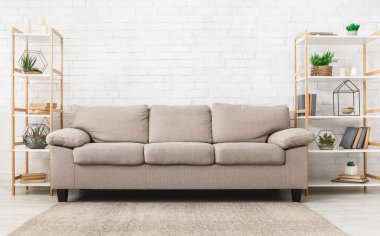 Beyaz tuğla duvar arka planda raflar üzerinde kanepe ve kapalı bitkiler ile oturma odası. Modern iç kavram, kopyalama alanı