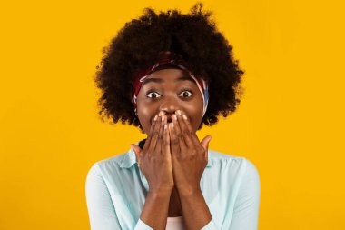 Vay canına. Heyecanlı siyah milenyum kadını elleriyle ağzını kapatıyor. Pembe stüdyonun arka planında sürpriz pozlar veriyor. Şaşırmış Kalça Kalçalı Kadın Portresi