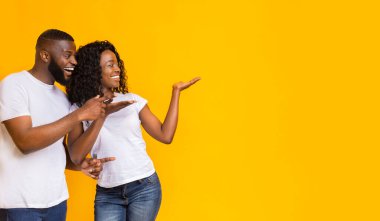 Neşeli Siyah Çift Boş Alan, sarı arka plan, panorama At Away İşaret ediyor